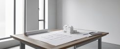 Agence d'architecture avec plans et maquette sur une grande table de travail
