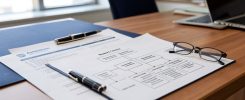 Documents d'immatriculation et organigramme d'une holding posés sur un bureau